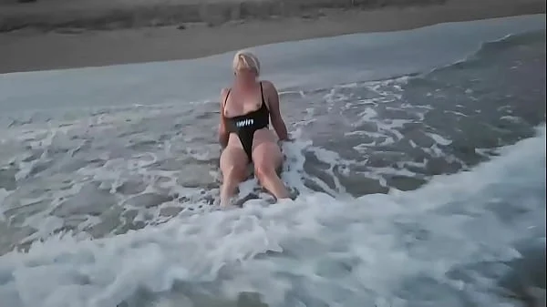 Blonde shows tits and sucks cock on a public beach