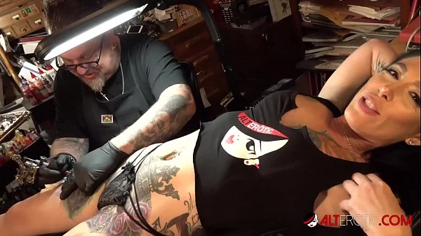 Marie Bossette touches herself while being tattooed